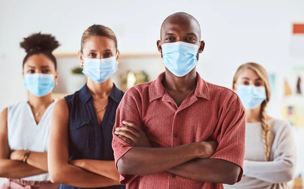 Covid, face mask and colleagues standing for safety and health in creative office with diversity, hygiene and leadership. Portrait of business people in healthy workplace during coronavirus.