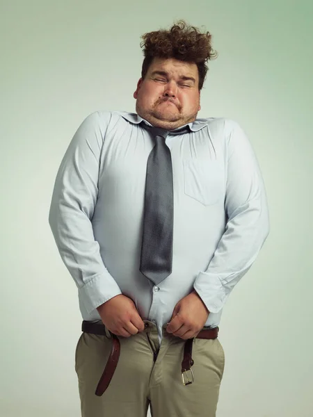 これはきつい絞ることになります 太りすぎの男がズボンを閉じるために彼の胃の中に吸い — ストック写真