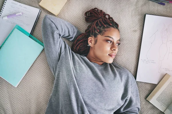 时尚专业的学生和躺在床上的黑人女人沉迷于自己的想法 思考和灵感 深思熟虑的年轻设计师在课间休息 有创意的学生 带着书本和图画在卧室里 — 图库照片