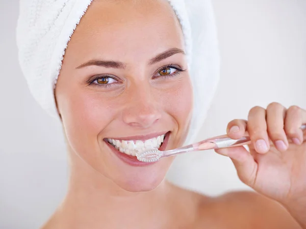 Keeping her gorgeous smile maintained. Close up of a pretty lady brushing her teeth
