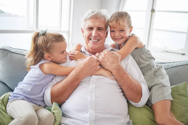 Happy family hug, love and grandfather with children, youth or grandkids playing together, bonding and have fun. Happiness and portrait of senior grandparent with kids relax on home living room sofa.