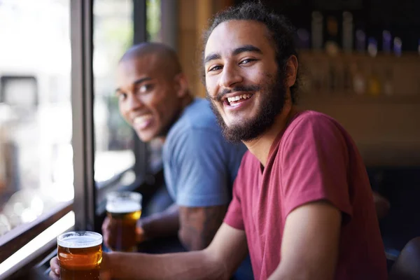 いいビールの上に良い笑い バーでビールを飲みながら座っている友人の切り取られたショット — ストック写真