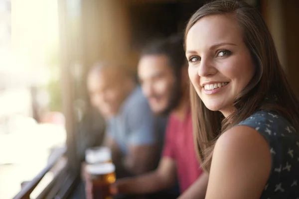 把椅子拉起来 一个微笑的年轻女子和几个朋友在酒吧里的画像 — 图库照片