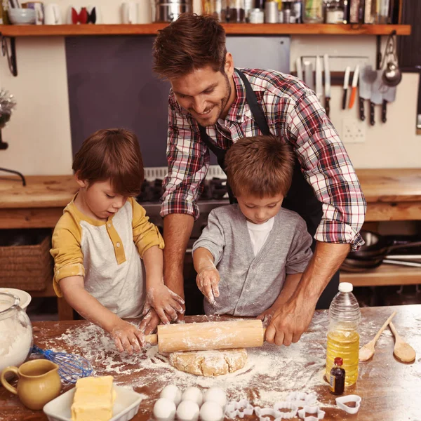 You boys are doing so well. Two cute little boys baking with their father in the kitchen