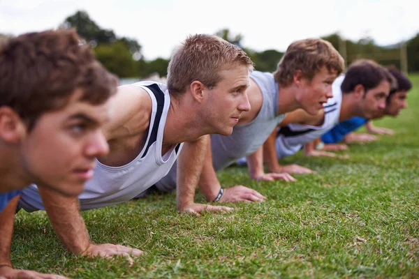 Hardcore strength training. a group of young sportsmen training outdoors