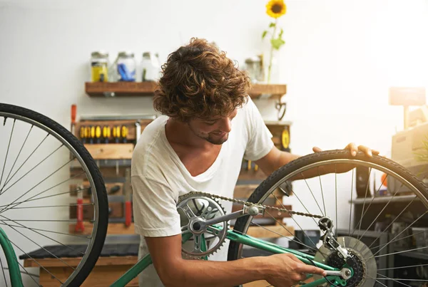 他对自行车了如指掌 车间里的年轻自行车修理工 — 图库照片