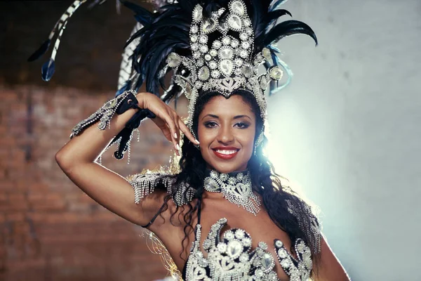 Live performances are her passion. a beautiful samba dancer wearing a headdress