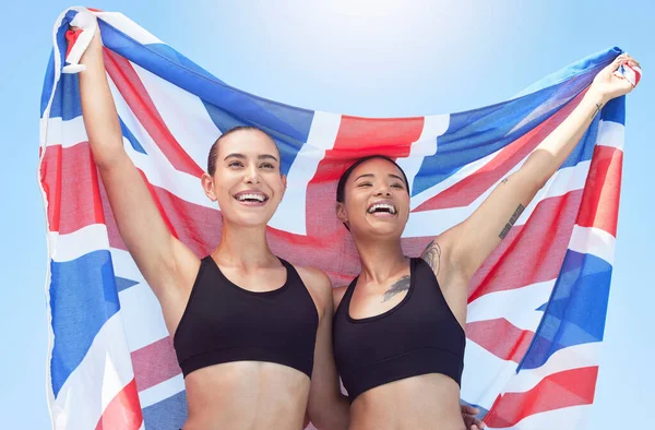 Sports women, athletes and british flag team winning celebration, event and international contest outdoor. Happy, excited and english united kingdom champion runners in motivation, pride and success.