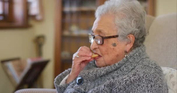 Starsza Kobieta Herbatniki Jedzenie Domu Opieki Salonie Lub Wewnętrznej Kanapie — Wideo stockowe