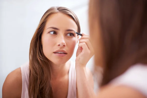 完璧なアーチを作る 鏡の前で眉をひそめている若い女性 — ストック写真
