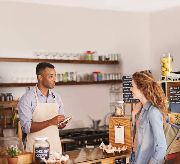 Would you like that to go. young barista taking a customers order at a cafe