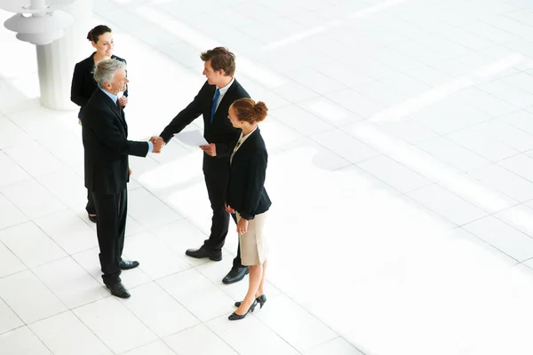 Haciendo Negocios Foto Ángulo Alto Dos Empresarios Estrechando Mano Vestíbulo —  Fotos de Stock