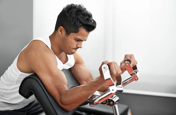 Hes always in the gym. A young ethnic man exercising in the gym