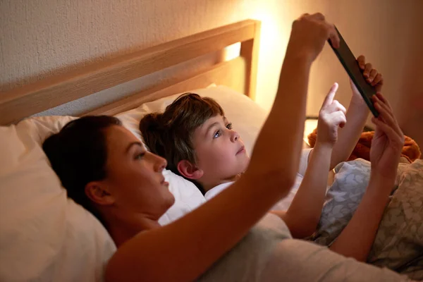 Interaktywne Opowieści Dobranoc Matka Syn Korzystający Tabletu Cyfrowego Razem Leżąc — Zdjęcie stockowe