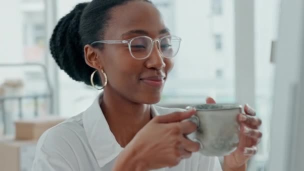 办公室里戴眼镜的黑人妇女在电脑前喝茶 阅读邮件或反馈报告时面带微笑 在午休时间 女商人可以一边喝咖啡 一边看视频或在网上看电视剧来放松自己 — 图库视频影像