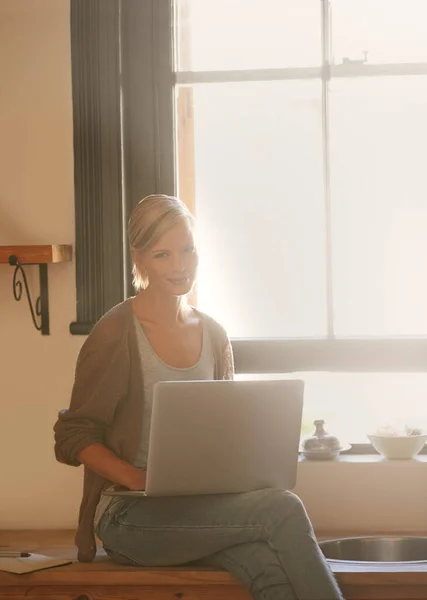 家里最温暖的工作场所 一个年轻貌美的女人在家里休息的时候用她的笔记本电脑 — 图库照片