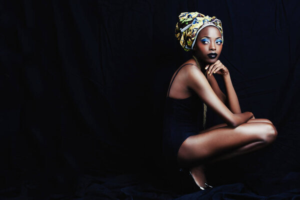 Looking back at copyspace filled with beauty. Full-length shot of a beautiful young african woman against a black background