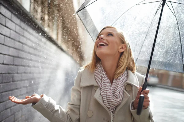 Lucky I brought my umbrella. a young woman walking down the street with an umbrella on a rainy day