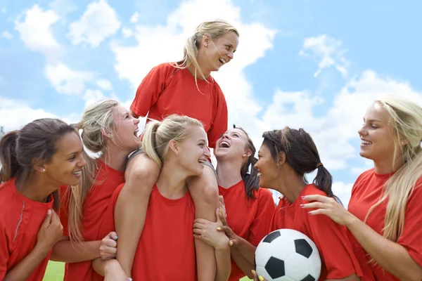 根本就没有竞争 一个女子足球队胜利地把队长扶起来的画像 — 图库照片