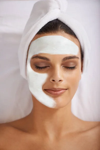 Nurturing her skin to perfection. a young woman enjoying a facial treatment at a spa