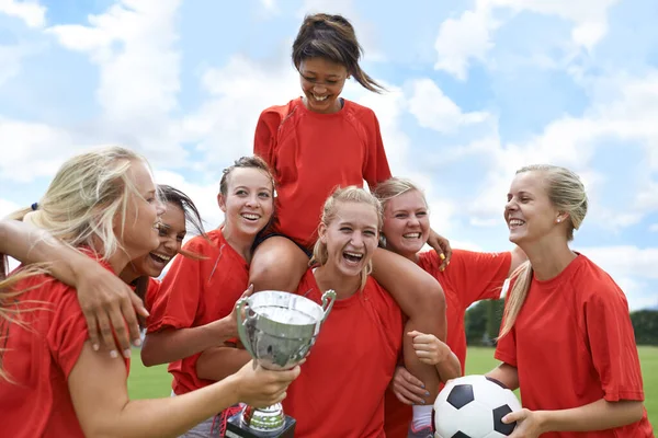 庆祝他们的联赛胜利 一个女子足球队胜利地把队长扶起来的画像 — 图库照片