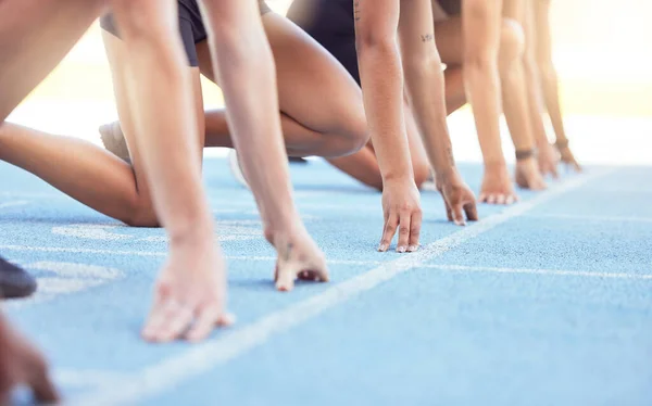 Runners with hands on start line on the track for a race, ready to run. Racing challenge or sprint at sports event with closeup for motivation, concentrate and focus in athletes running on track.