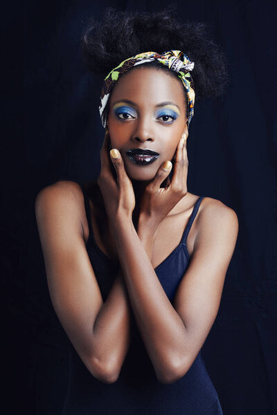 Shes a true african beauty. A beautiful african woman posing against a black background