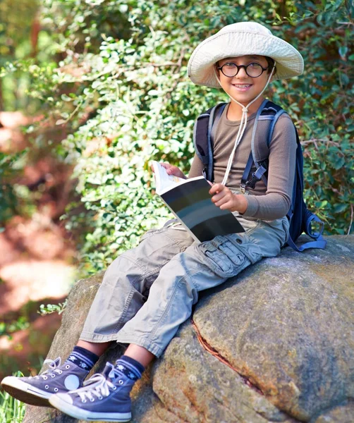 在猫头鹰身上看书 一个小男孩 手里拿着一本书 坐在岩石上 — 图库照片