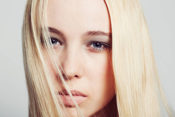 Soft but serious. Closeup portrait of a beautiful young blonde woman gazing intently into the camera