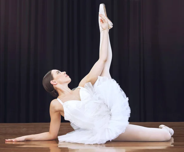 Ballet, theatre and dancer in a stage performance showing balance, flexibility and elegant movement. Creative, concert and young woman is an artistic ballerina dancing in a classy and feminine style.