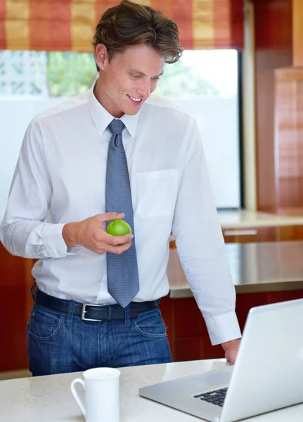 Pobyt Poinformowany Online Mężczyzna Trzymający Jabłko Kawę Podczas Używania Laptopa — Zdjęcie stockowe