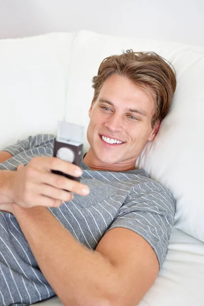 Mesaj Günümü Güzelleştirdi Yatarken Gülümseyen Telefon Tutan Genç Bir Adam — Stok fotoğraf