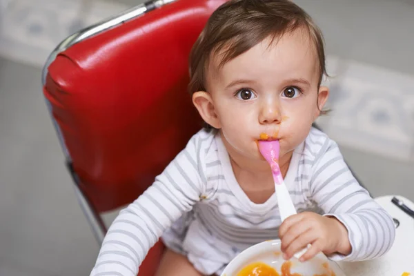 什么是甜点 一个可爱的小宝宝坐在高高的椅子上吃饭的画像 — 图库照片