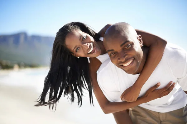 假日快乐 一个英俊的非洲裔美国男人在海滩上给他的女朋友搭便车 — 图库照片