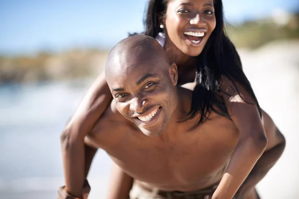 我的男人很强壮一个英俊的非洲裔美国男人在海滩上给他的女朋友搭便车 — 图库照片