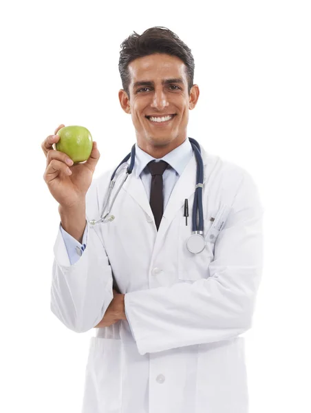 リンゴの日 ラボのコートと聴診器を着て白い背景にリンゴを持っている笑顔のハンサムな医者 — ストック写真