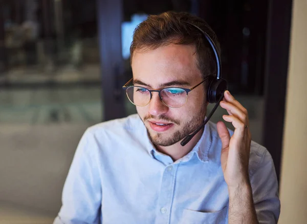 Call center, customer service and telemarketing with a man working in support with a headset in his office. Sales, consulting and contact us with a male consultant at work in crm communication.