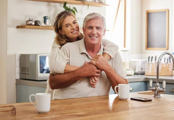 Senior couple, smile and love while hugging in kitchen drinking coffee, relax and bonding feeling happy, support and trust. Portrait of old Australia man and woman in healthy relationship or marriage.