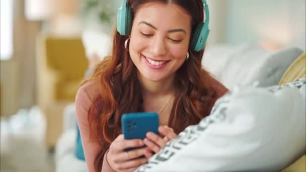 Chica Teléfono Música Sofá Para Relajarse Con Auriculares Con Sonrisa — Vídeos de Stock