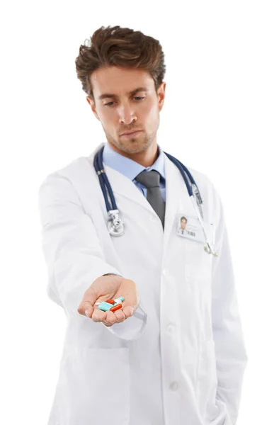这是推荐的剂量 一个长相严肃的年轻医生拿着一盘药丸站在摄像机前的摄影棚照片 — 图库照片