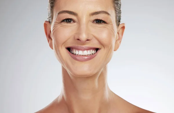 グレーのモックアップスタジオの背景に顔の健康のための笑顔を持つ成熟した女性のための顔 肖像画やスキンケア 天然の健康とモックアップスペースと皮膚科について幸せな高齢者モデル — ストック写真