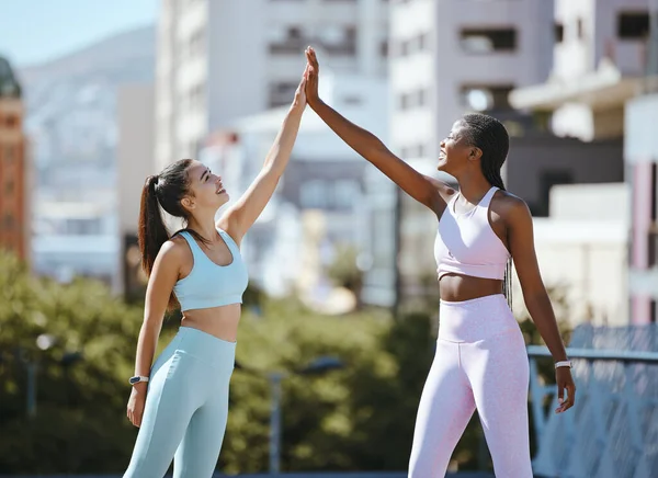 Fitness, women and friends high five after running, training and cardio workout success together outdoors in summer. Winners, sports and happy runners in celebration of health and wellness team goals.