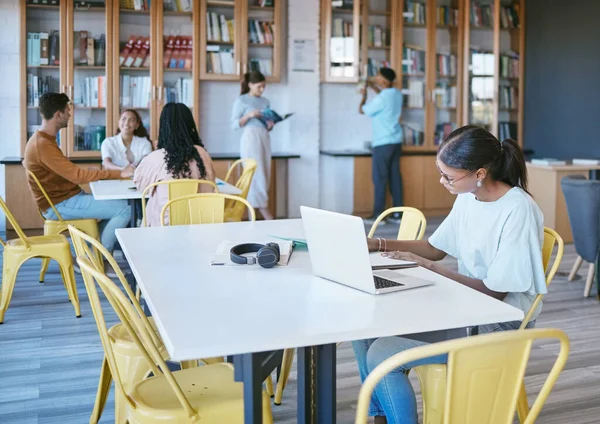 Studying, library and student in university writing ideas in notebook, planning research strategy on laptop for course work. Community, education and knowledge with college people learning and books.