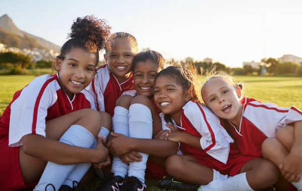 Team, soccer or happy sports girl with smile on field, grass or stadium for health, teamwork or wellness portrait. Children, football or exercise with support, diversity or motivation for sports game.