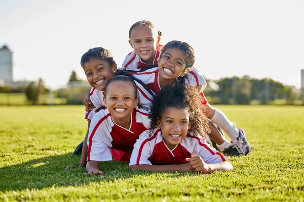 Soccer, training and children on sports field for football game, exercise or cardio together. Portrait of girl kids, athlete group and players with smile and partnership, teamwork and sport at school.