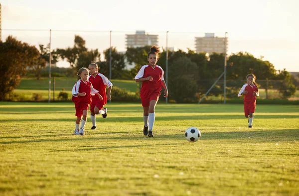 スポーツ フィットネス サッカーの試合中に芝生のフィールド チームワークで遊ぶ少女チームによるサッカーのトレーニング エネルギーやサッカーボールとの競争力のある試合でプレーすることを学ぶ子供たち — ストック写真