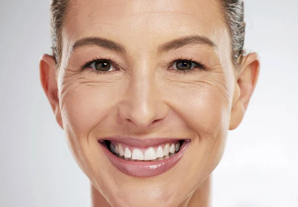 面部妆容 美容美发 成熟的女人带着笑容面对灰色的造型工作室背景 一个喜欢面部护理和健康的老年模特的肖像头像 — 图库照片