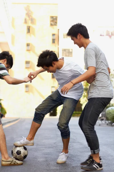 Якась Товариська Конкуренція Троє Азіатських Хлопчиків Грають Футбол Вулиці — стокове фото