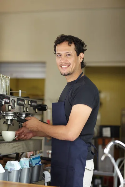 Coffee is his passion. Portrait of a male barista preparing coffee