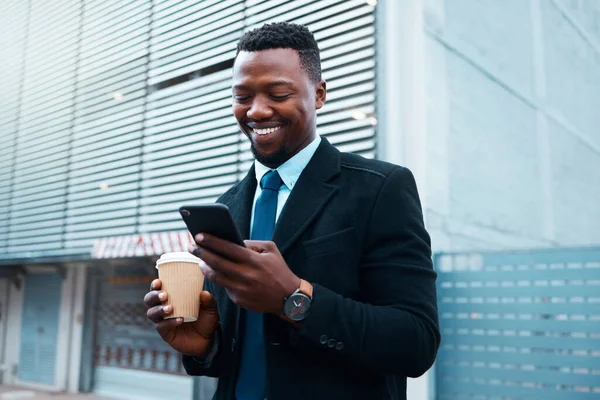 Coffee, social media and businessman on his phone in the city of Singapore with smile in morning. Happy, corporate and African employee reading chat on mobile phone with drink of tea and 5g internet.